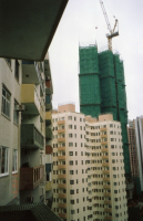 A high-rise building under construction is covered completely by bamboo scaffolds to form working platforms and scrambling units. 2007
