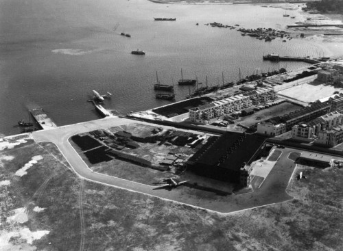 Kai Tak Kai Tak airport, pre-war, showing the main hangar and a flying boat tied up at the Pan Am pontoon. Gregory Crouch