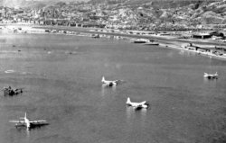 11 RAF Sunderlands And A US Navy Martin Mariner Flying Boats At Rest In The Bay Off Kai Taks Seawall